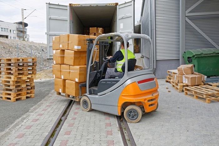 A forklift loading boxes into a truck.