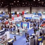 Multiple booths and people attending a tradeshow.