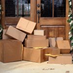 Multiple boxes and packages sitting on a porch.