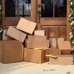 Multiple boxes and packages sitting on a porch.