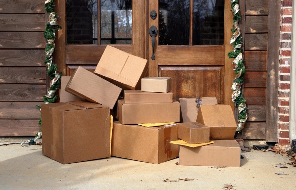 Multiple boxes and packages sitting on a porch.