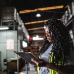 Warehouse worker writing in a clipboard