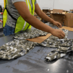 worker folding sweatshirt at apparel fulfillment company