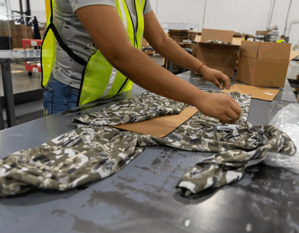 worker folding sweatshirt at apparel fulfillment company